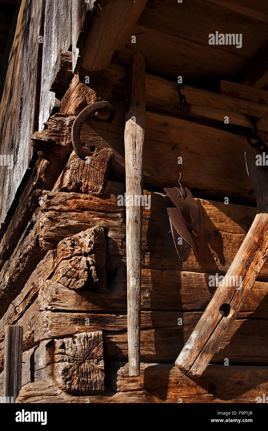 Tacche a coda di rondine su un vecchio log cabin, un ferro di cavallo e attrezzi agricoli presso il Museo degli Appalachi, Tennessee, Stati Uniti d'America. Foto Stock