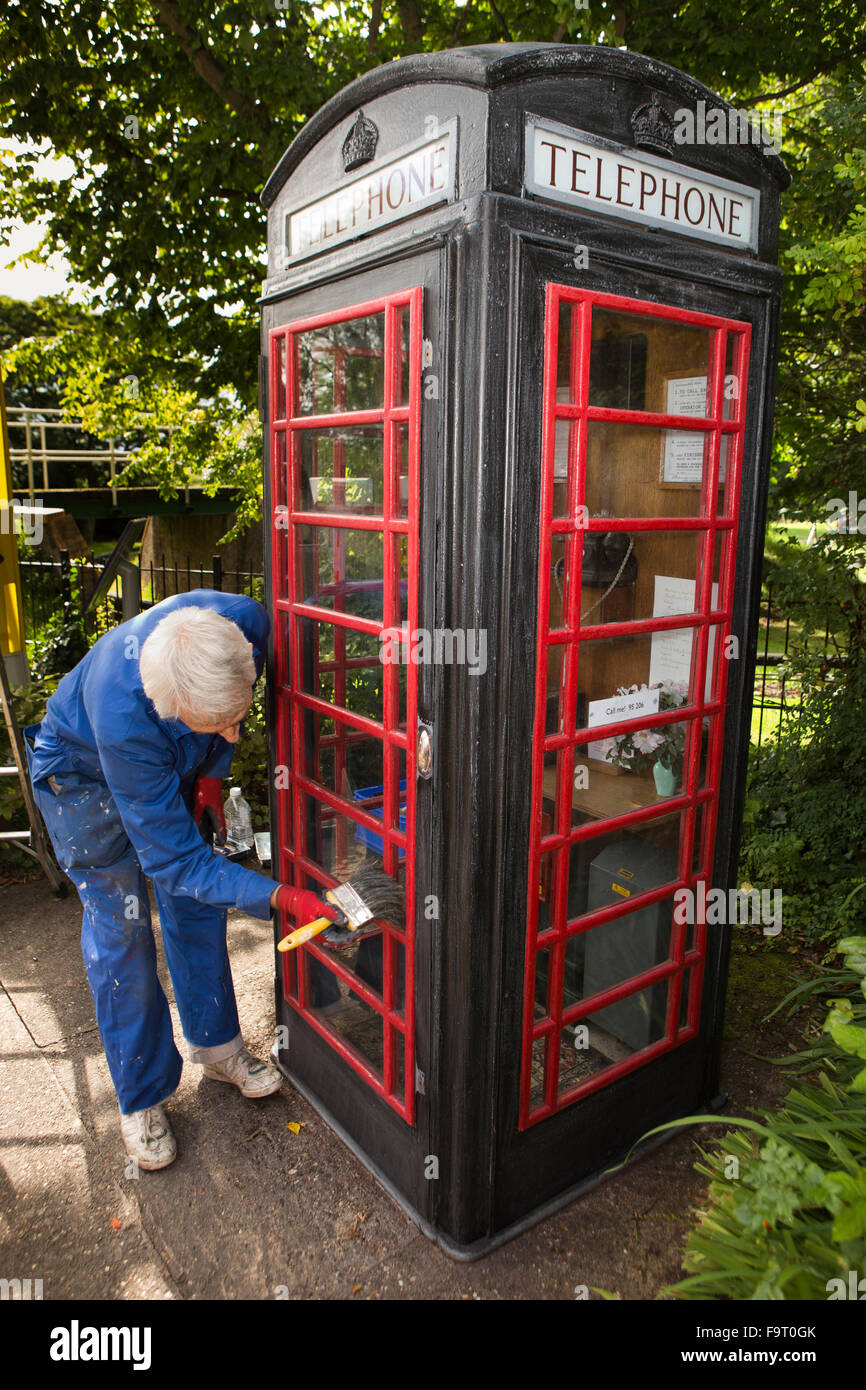 Regno Unito, Inghilterra, Worcestershire, Bromsgrove, Avoncroft Museum, telefonica nazionale di raccolta Kiosk, volontario Roger toccando la pittura Foto Stock