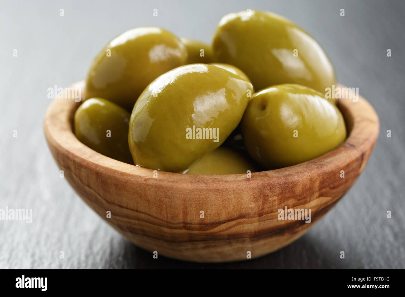 Giant olive verdi in vaso di olive su sfondo di ardesia Foto Stock