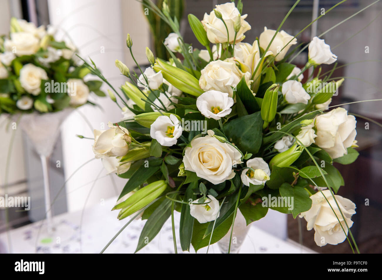 Bianco bouquet di fiori sul display con foglie di colore verde Foto Stock