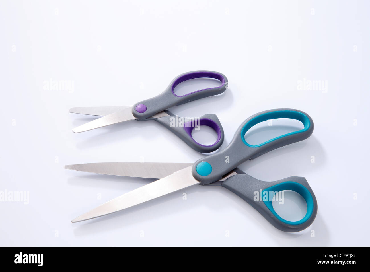 2 paio di forbici che uno di piccole e grandi dimensioni su sfondo bianco Foto Stock
