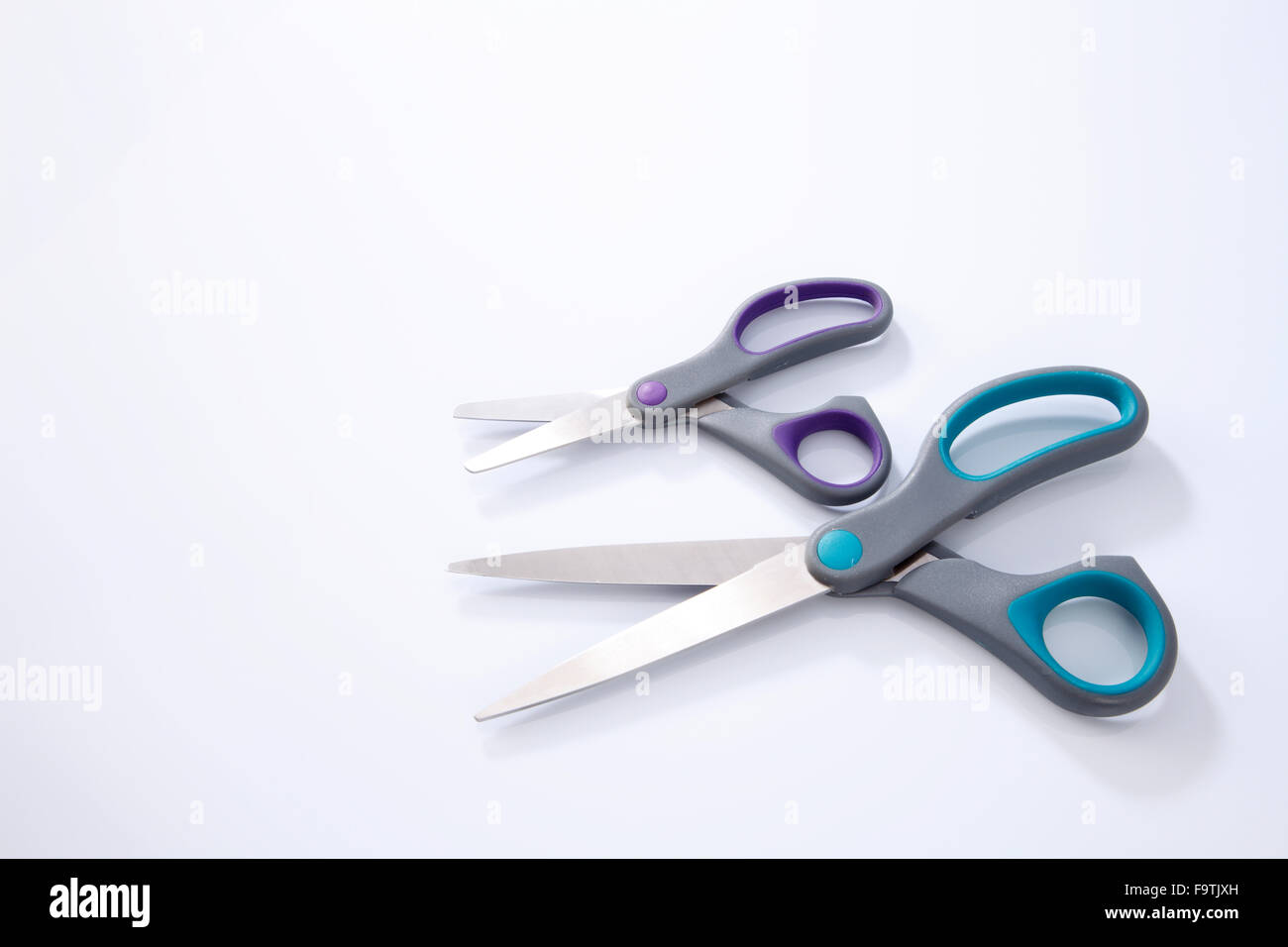 2 paio di forbici che uno di piccole e grandi dimensioni su sfondo bianco Foto Stock