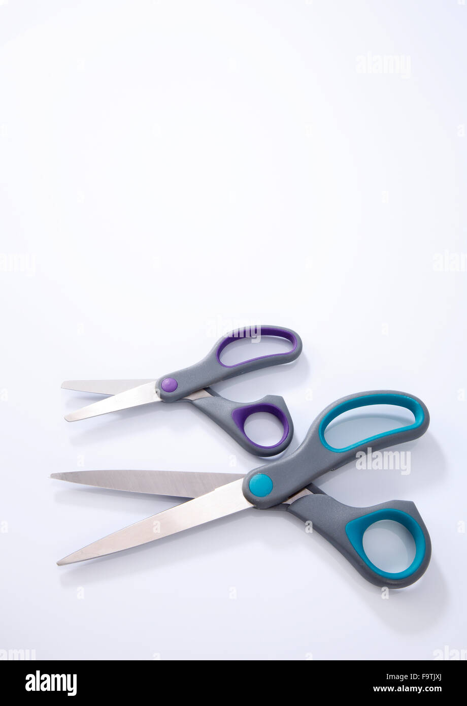 2 paio di forbici che uno di piccole e grandi dimensioni su sfondo bianco Foto Stock