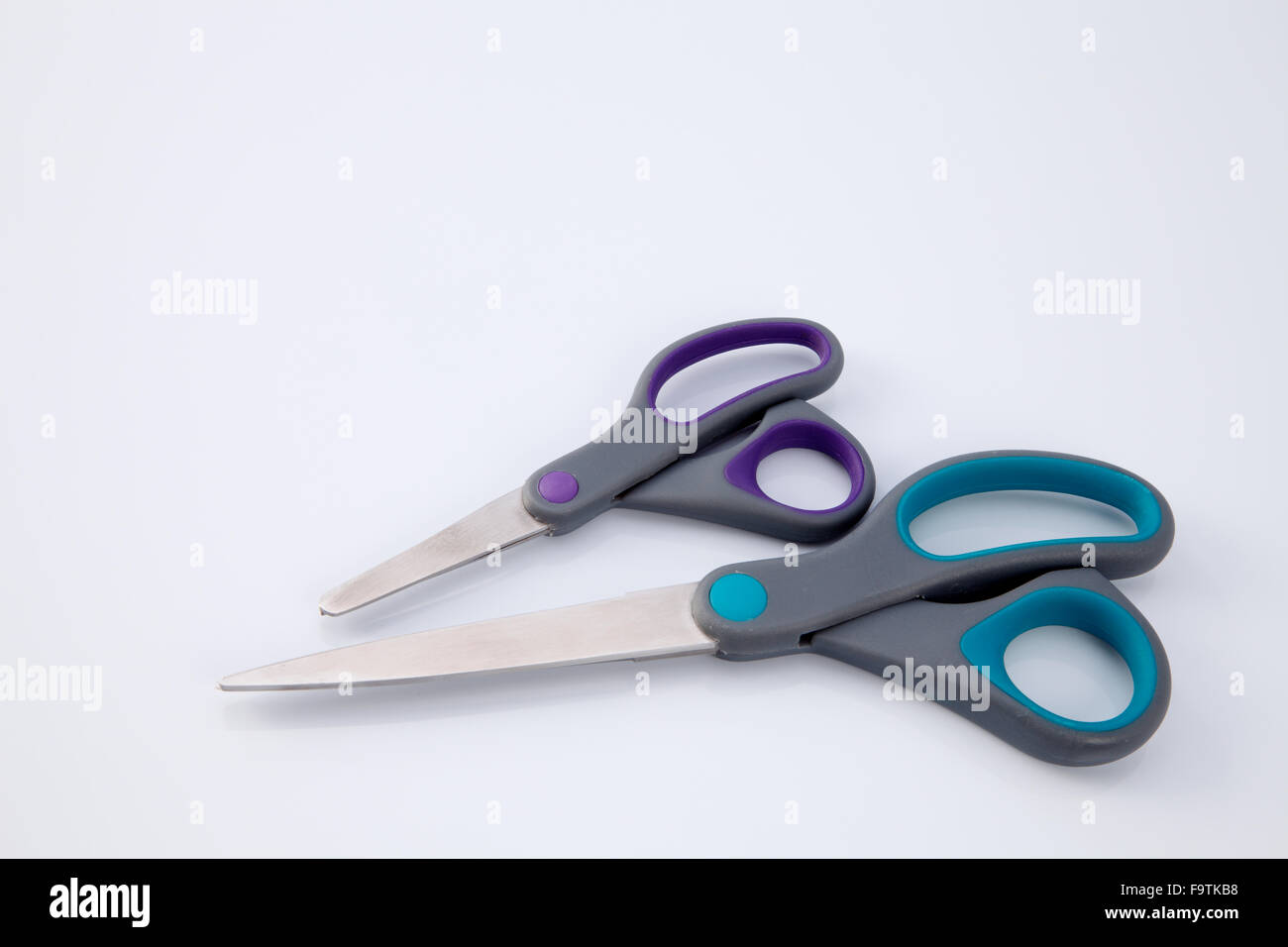 2 paio di forbici che uno di piccole e grandi dimensioni su sfondo bianco Foto Stock