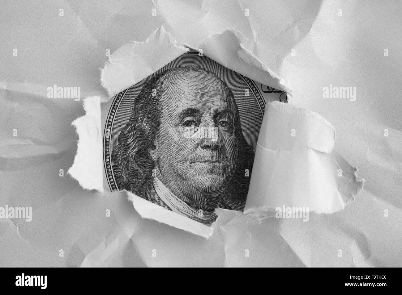 Benjamin Franklin faccia da un centinaio di dollari banconota guardando attraverso la presenza di frammenti di carta. Immagine in bianco e nero. Primo piano. Foto Stock