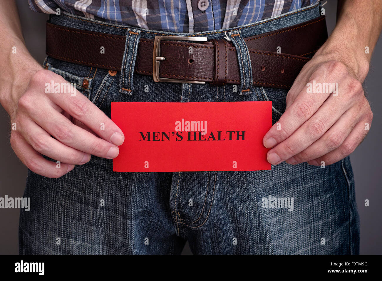 Gli uomini del concetto di salute. Uomo con red pezzo di carta con la frase la salute degli uomini nelle sue mani. Foto Stock