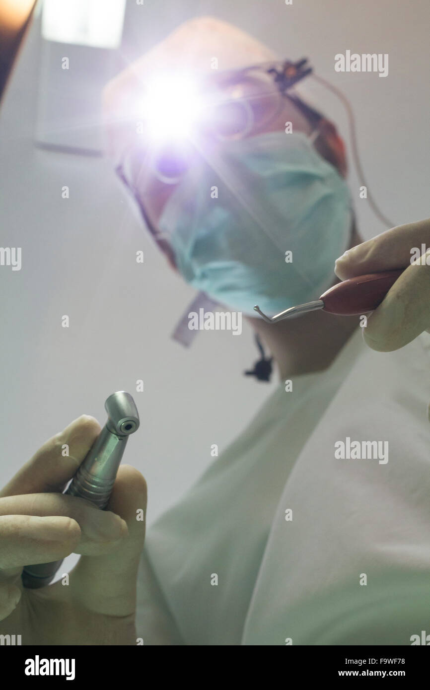 Dentista con occhiali con lenti di ingrandimento pronto per il trattamento di un paziente Foto Stock