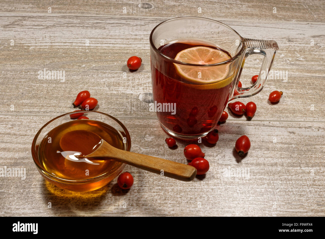 Rosa anca tè con miele e limone sul tavolo di legno Foto Stock