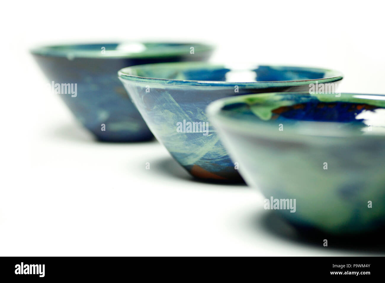 Blu di coppe in ceramica realizzato da Sally Bettridge isolato su un bianco di sfondo per studio. Foto Stock