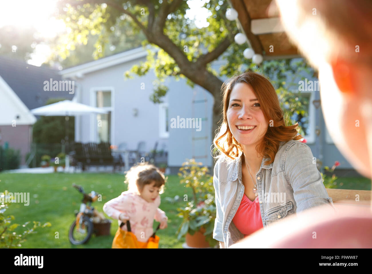 Madre sorridente con la figlia in giardino Foto Stock