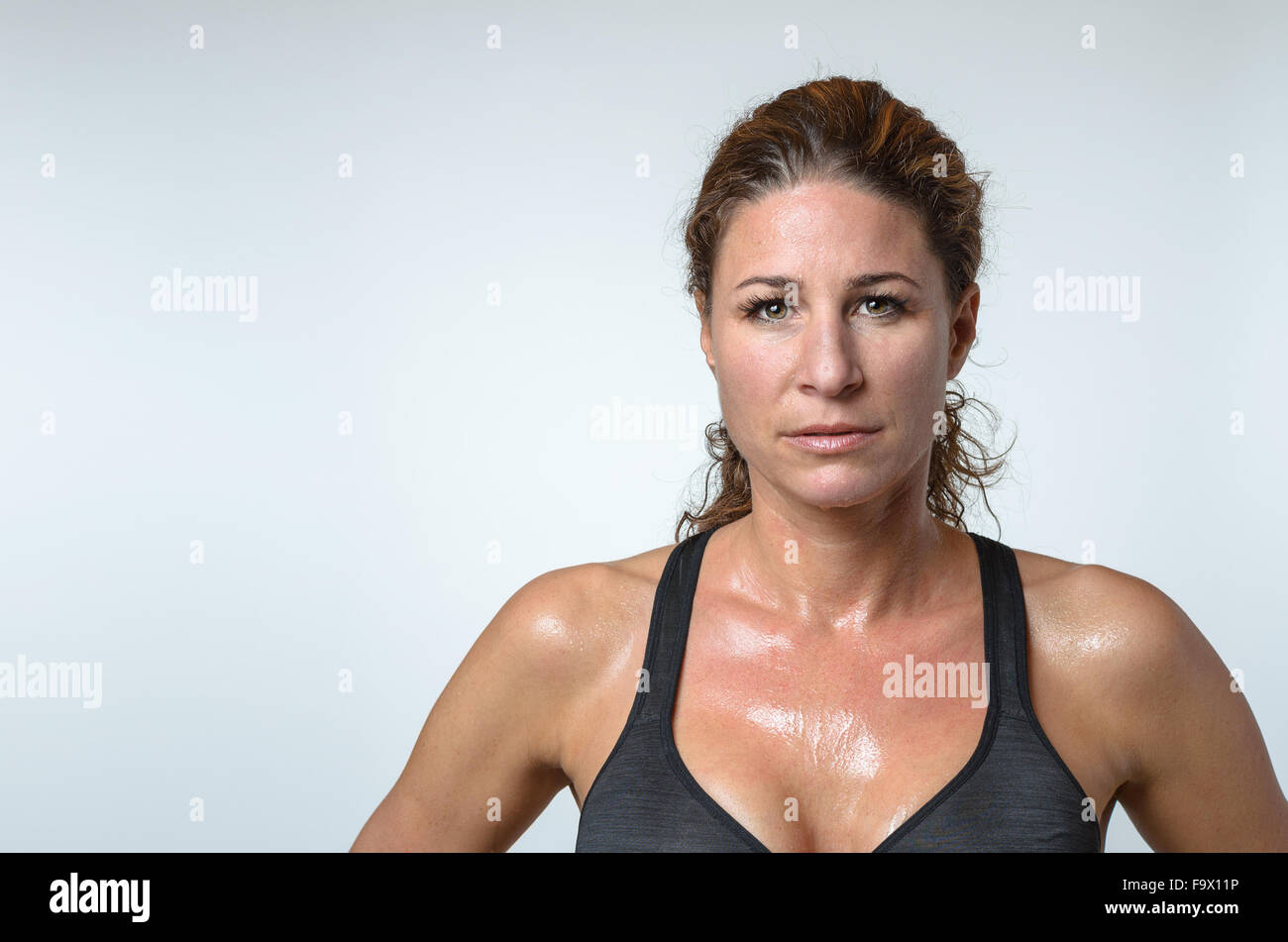 Sudati attraente montare atletica giovane donna con una patina di sudore  sulla sua pelle e bella capelli ricci guardando la telecamera Foto stock -  Alamy