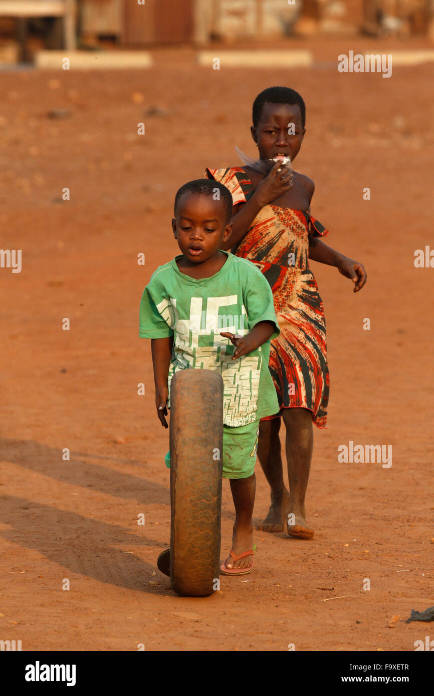 Ragazzo africano giocando con un vecchio pneumatico. Foto Stock