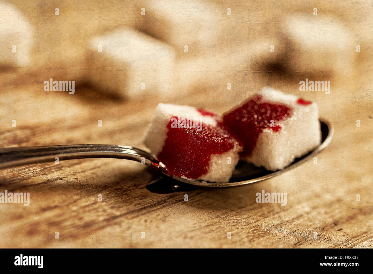 Zollette di zucchero con il sangue sul cucchiaio Foto Stock