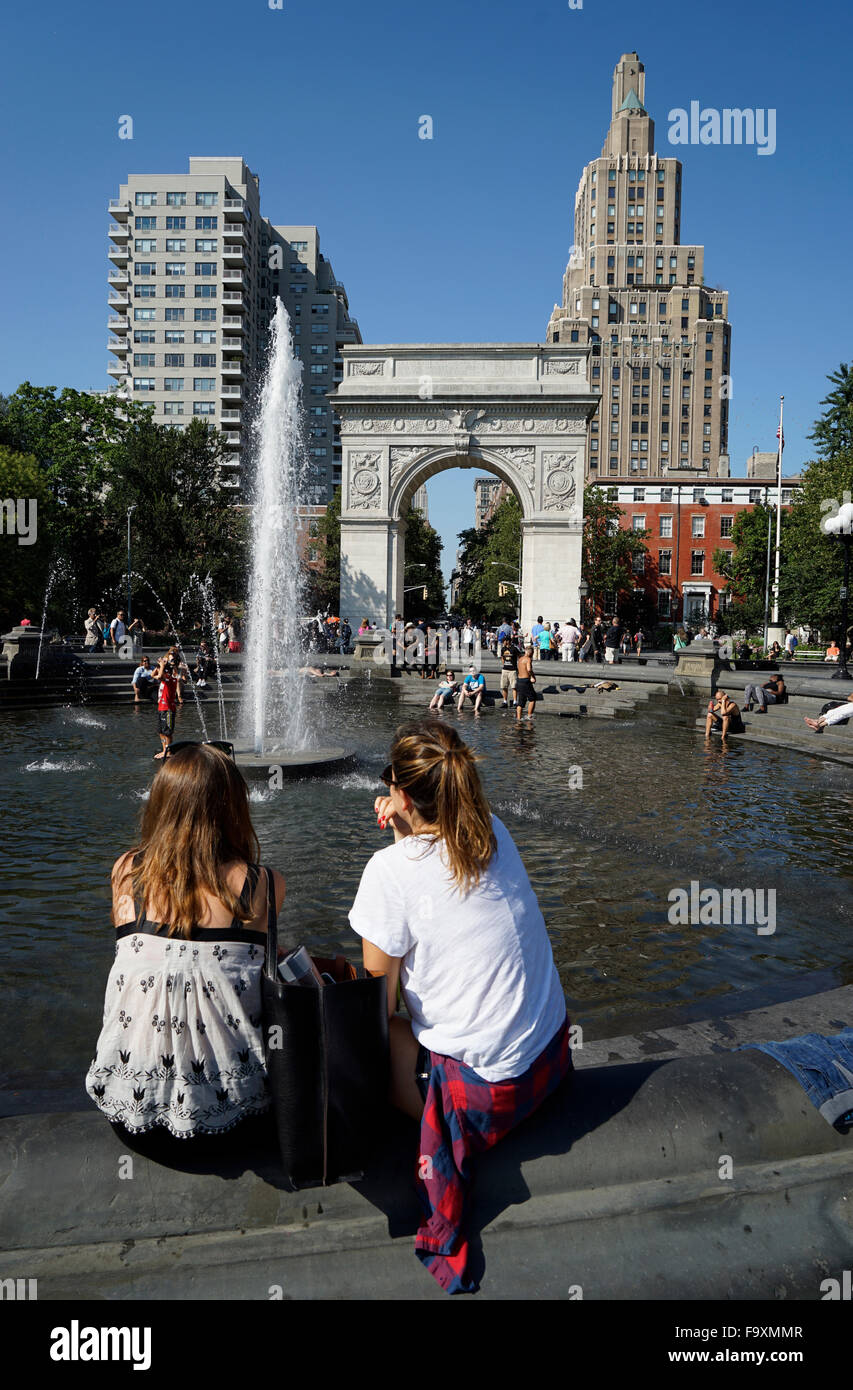 Visitatori relax presso la fontana centrale a Washington Square Park con Washington Square Arch in background, New York City Foto Stock
