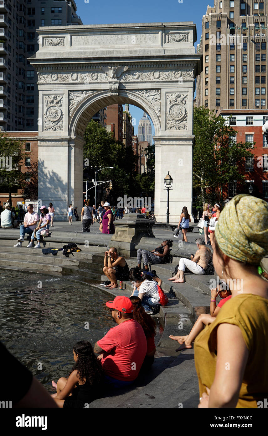 Visitatori relax presso la fontana centrale a Washington Square Park con Washington Square Arch in background, New York City Foto Stock