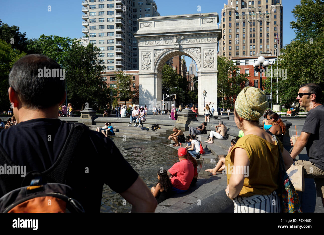 Visitatori relax presso la fontana centrale a Washington Square Park con Washington Square Arch in background, New York City Foto Stock