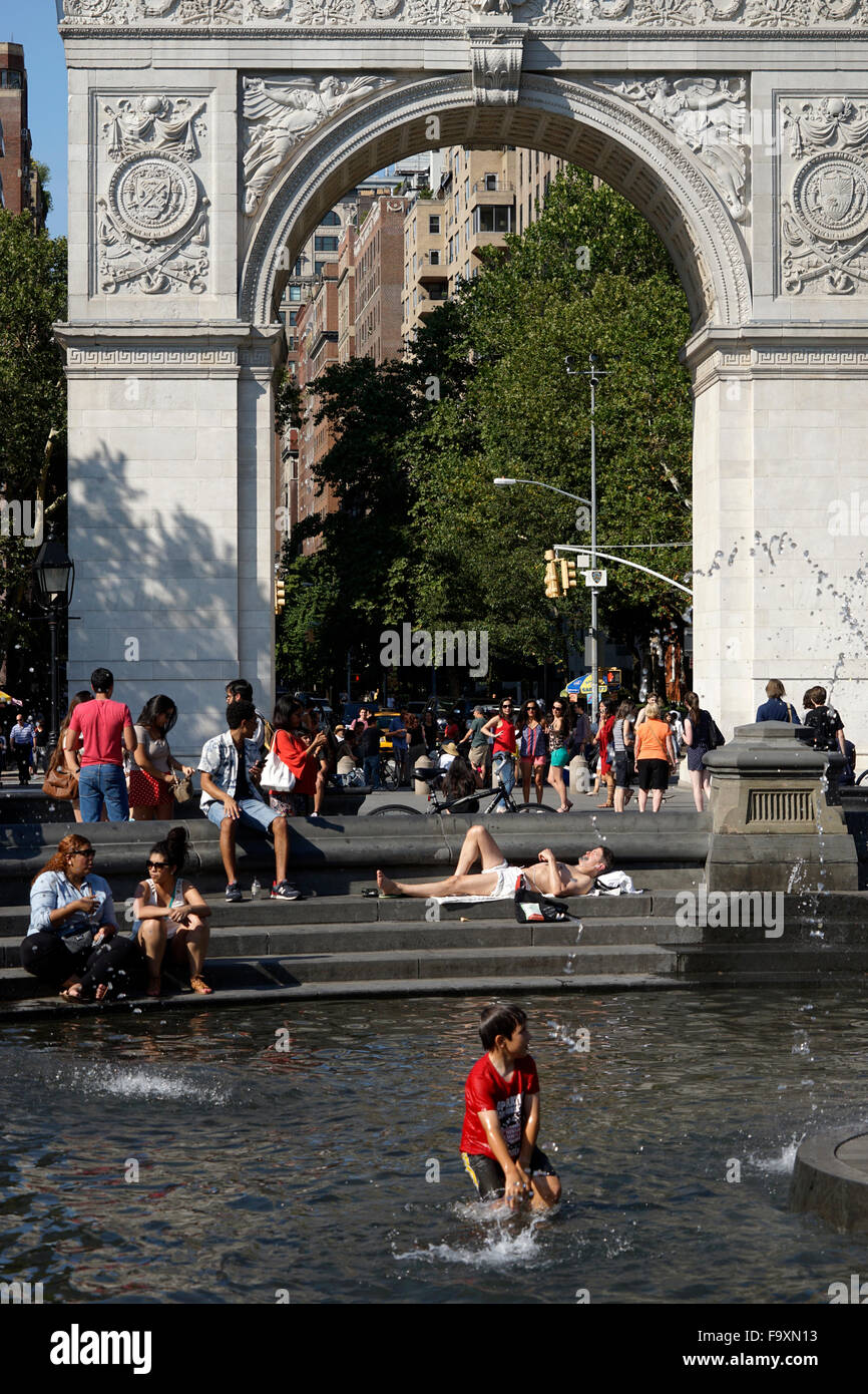 Visitatori relax presso la fontana centrale a Washington Square Park con Washington Square Arch in background, New York City Foto Stock