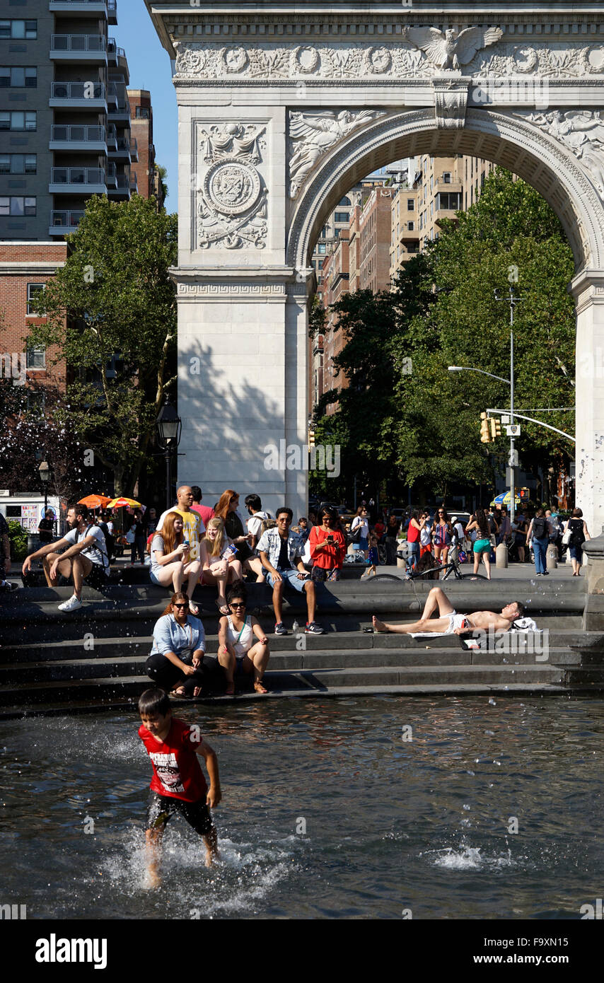 Visitatori relax presso la fontana centrale a Washington Square Park con Washington Square Arch in background, New York City Foto Stock