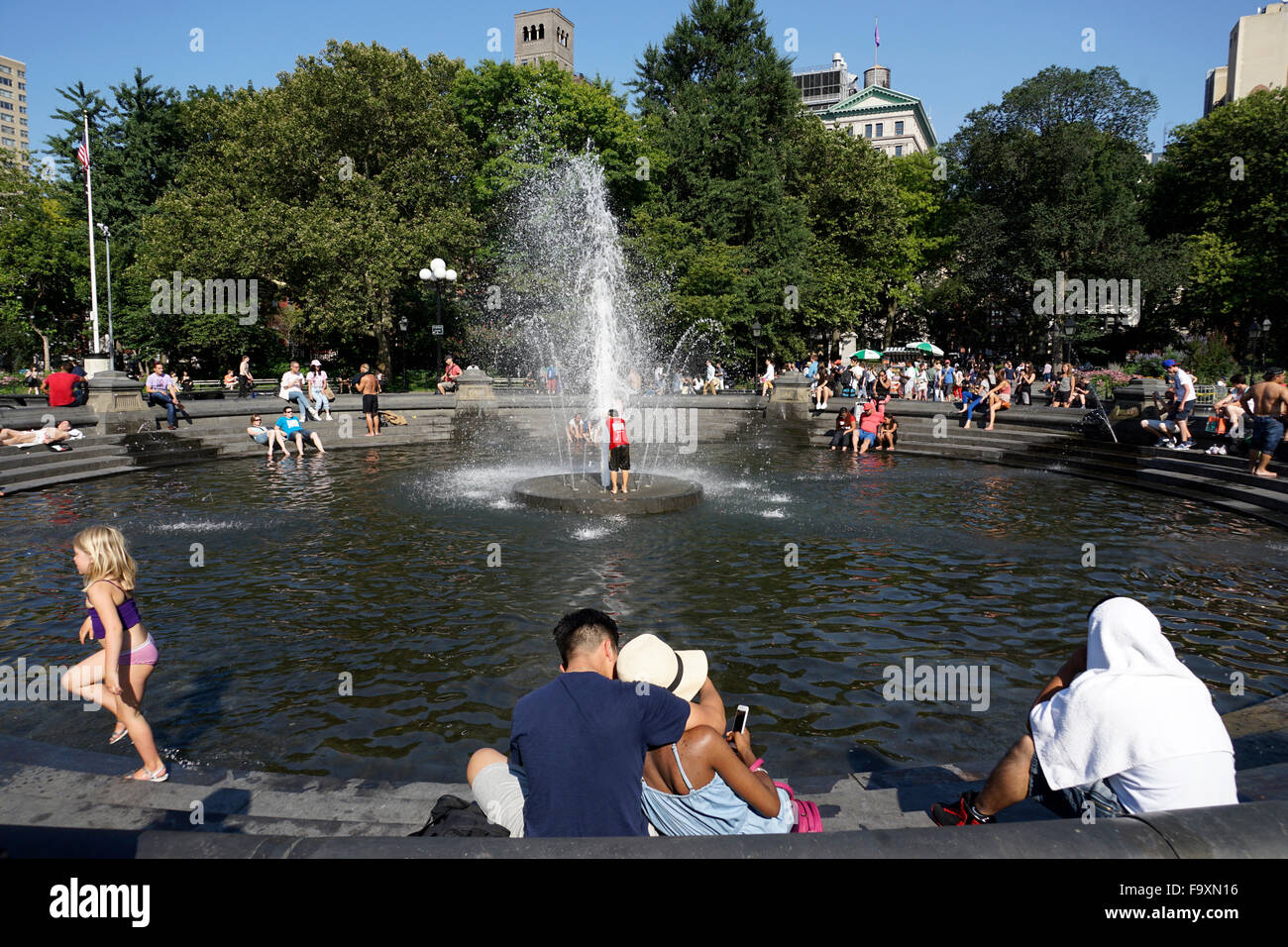 Visitatori relax presso la fontana centrale a Washington Square Park. Il Greenwich Village di New York City, Stati Uniti d'America Foto Stock
