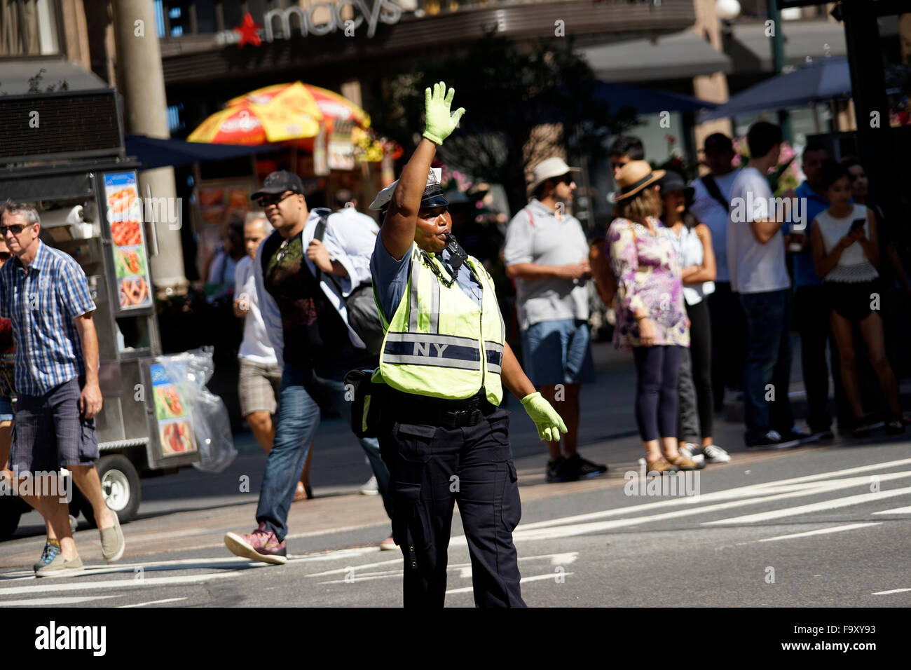 Donna di polizia dirigere traffico nei pressi di Herald Square nel centro cittadino di Manhattan, New York City, Stati Uniti d'America Foto Stock
