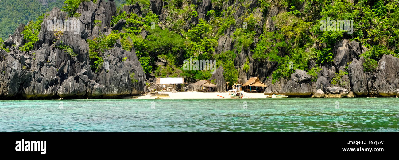 Isola rocciosa con capanne Nipa case su una solitaria spiaggia di sabbia bianca Foto Stock Isola rocciosa con capanne Nipa case su una solitaria spiaggia di sabbia bianca Foto Stock