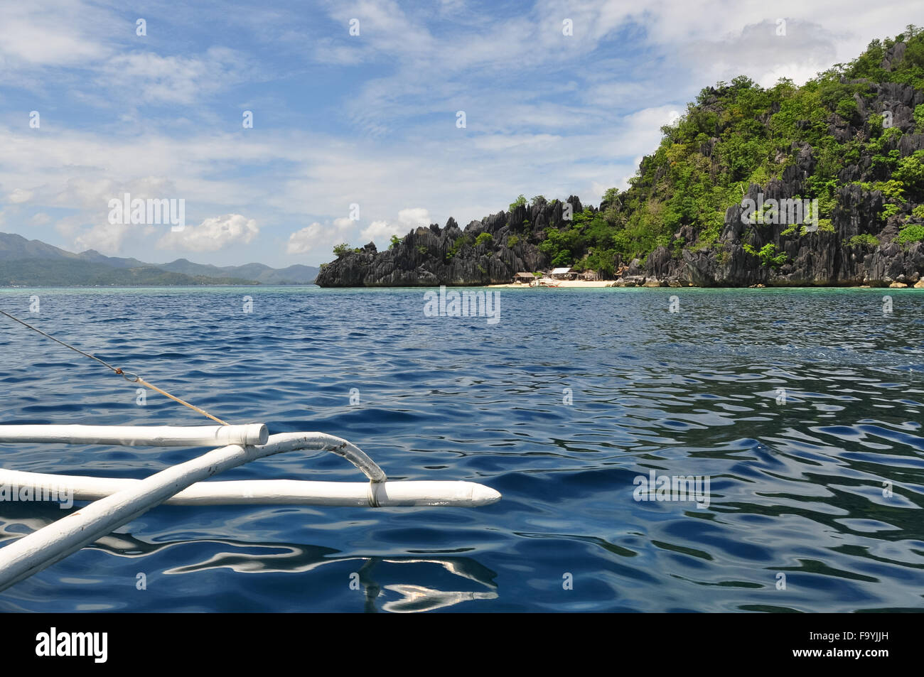Lato di un legno barca filippino rivolta verso il blu del mare e del cielo con le nuvole Foto Stock