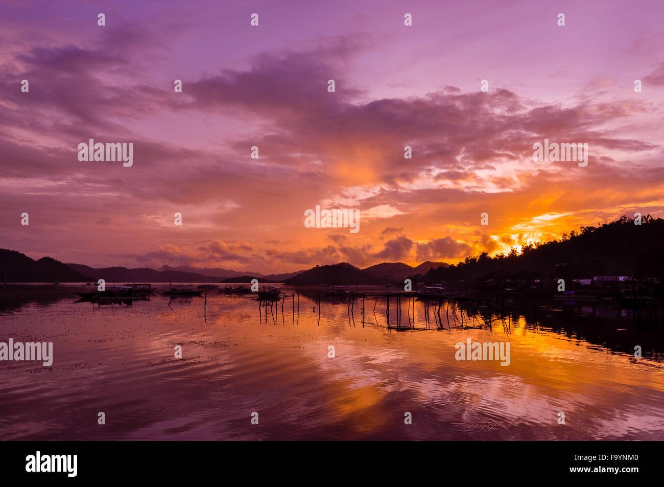 Rosa grazioso Orange Sky cloudscape sull isola con la riflessione al tramonto sull'Isola di Coron Foto Stock