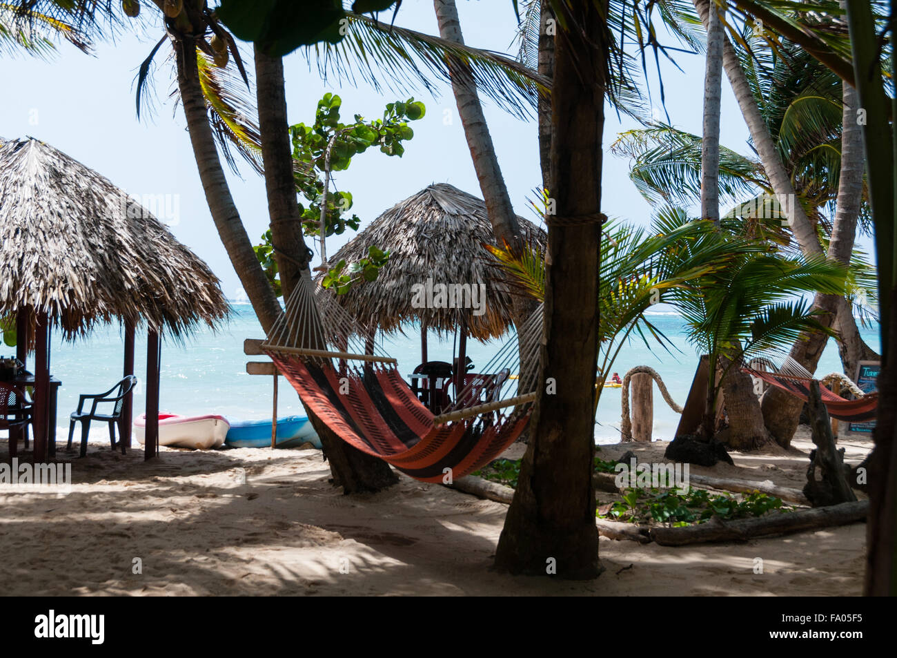 Due capanne con tavoli sedie e amaca presso la spiaggia di sabbia bianca di fronte il mare dei Caraibi Foto Stock