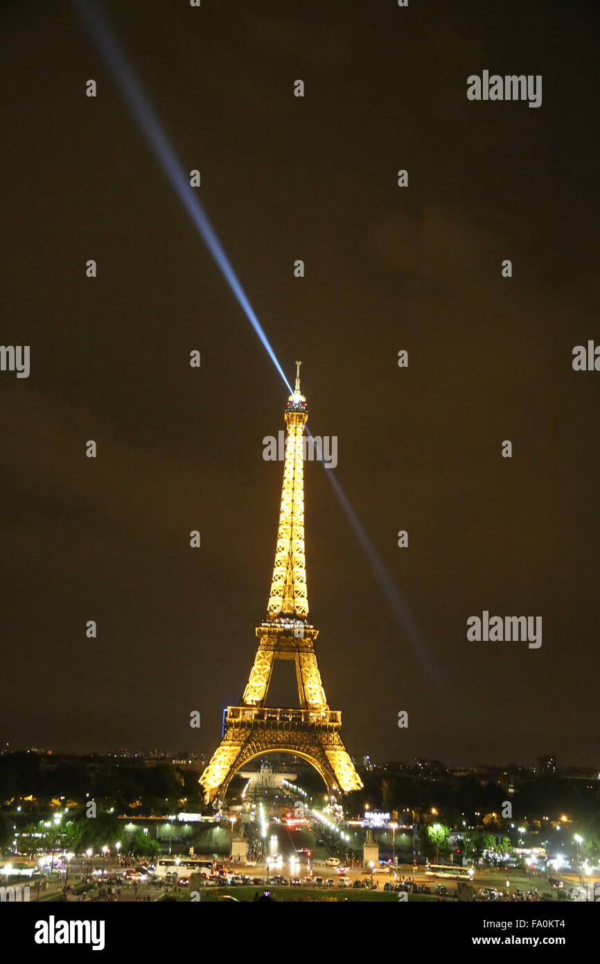 La torre Eiffel di notte con la luce di ricerca sulla punta della torre diagonalmente trainato in background e canoni d'acqua.. Foto Stock
