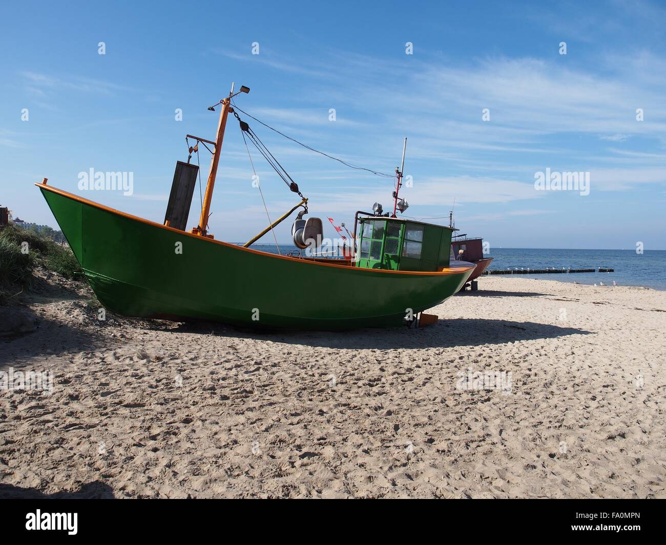Verde di barca da pesca in mare costa su sfondo cielo Foto Stock