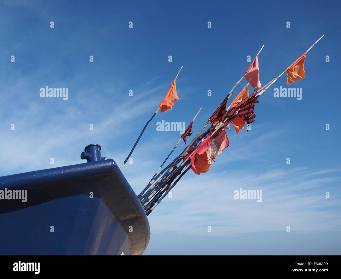 Frammento blu barca da pesca con bandiera a costa del mare Foto Stock