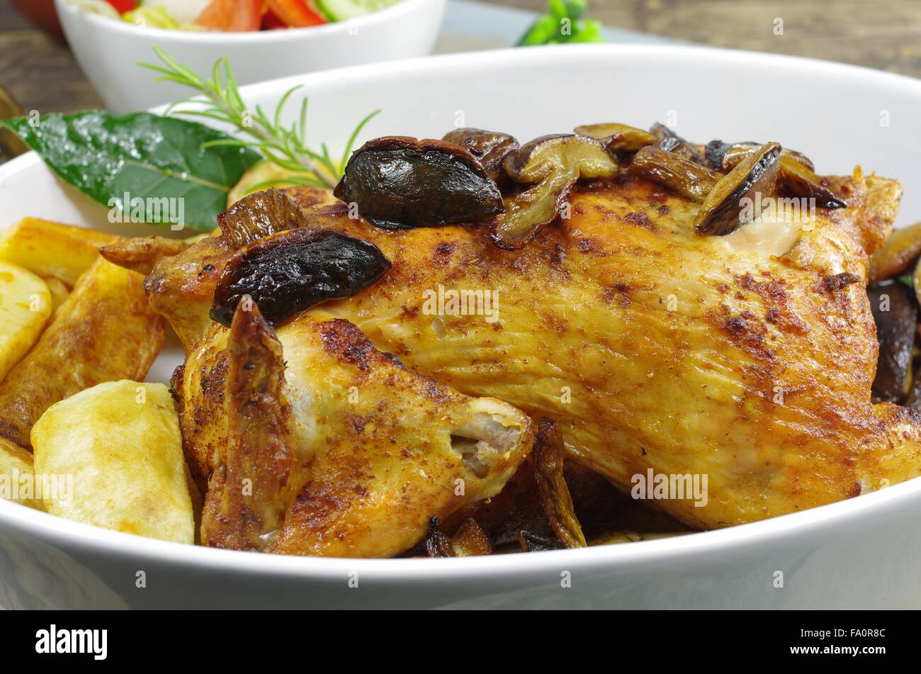 Il pollo al forno con patate funghi e foglie di alloro Foto Stock