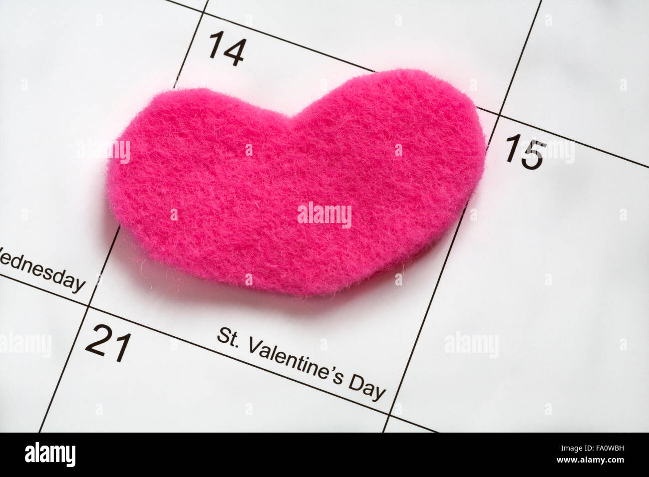 Feltro rosa cuore collocato su San Valentino sul calendario Foto Stock