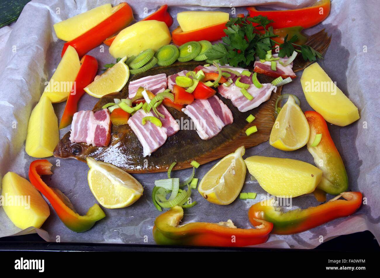 Pesce crudo passera di mare con verdure e pancetta Foto Stock