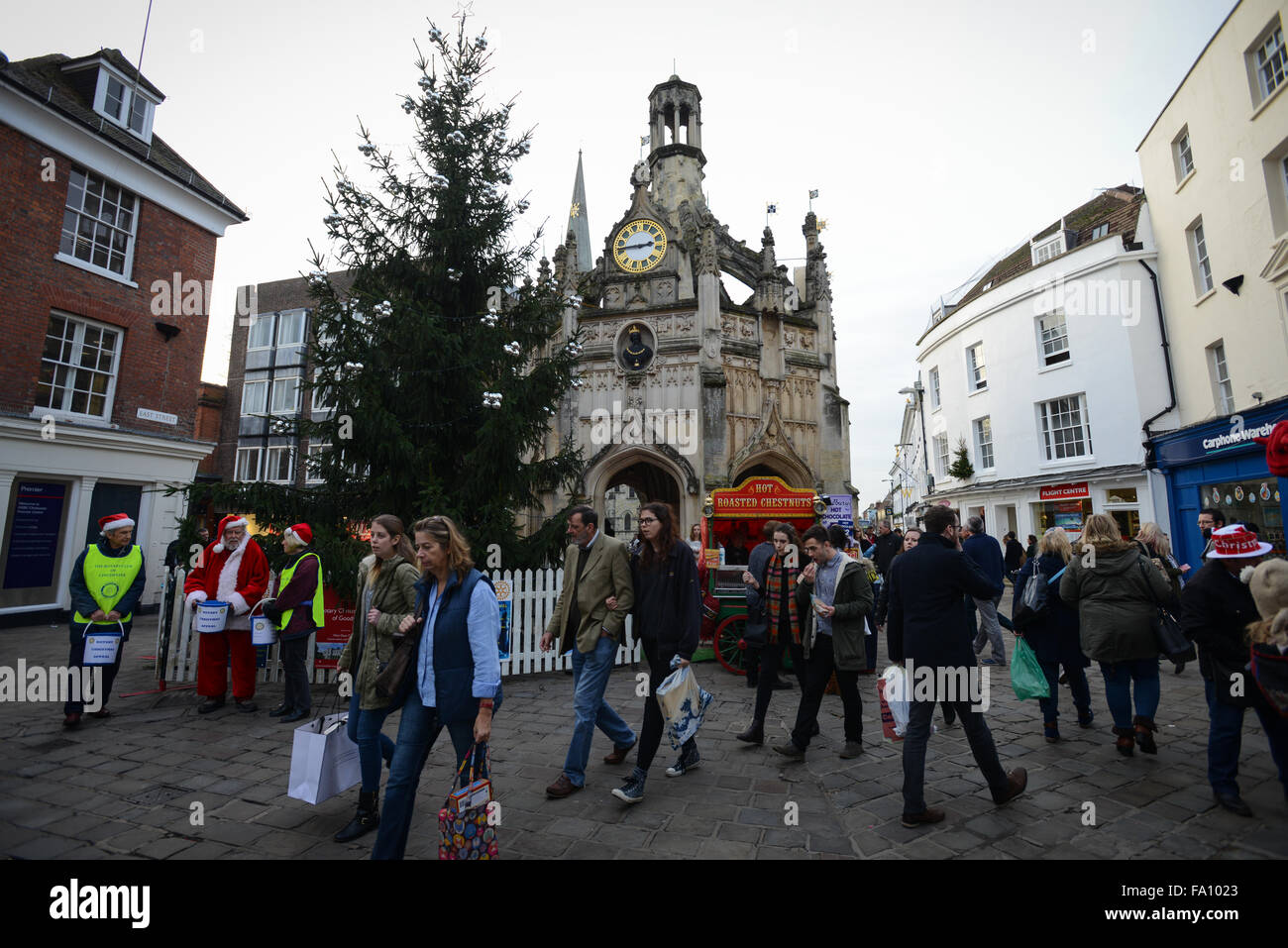 Christmas Shopper passano davanti al Chichester Croce di mercato pur fare alcuni acquisti all' ultimo minuto dell'ultimo sabato prima di Natale a Chichester, West Sussex, in Inghilterra. Foto Stock