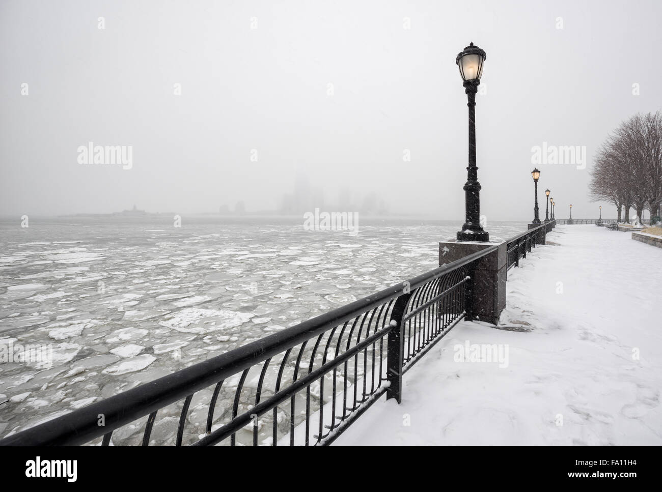 Congelati Fiume Hudson da snowy Battery Park verso la città di Jersey nella nebbia. Una silenziosa giornata invernale nella Città di New York Foto Stock