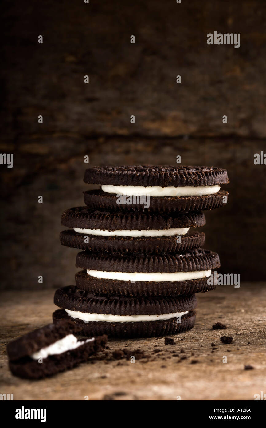 Biscotti al cioccolato con crema vaniglia riempire sopra lo sfondo di legno Foto Stock