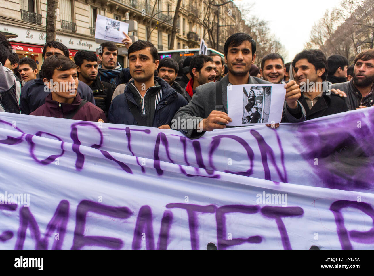Parigi, Francia. Immigrati migranti rifugiati dimostrazione, folla di persone davanti con l'Afghanistan Man con un cartello di protesta in strada, proteste per i diritti dei cittadini Foto Stock