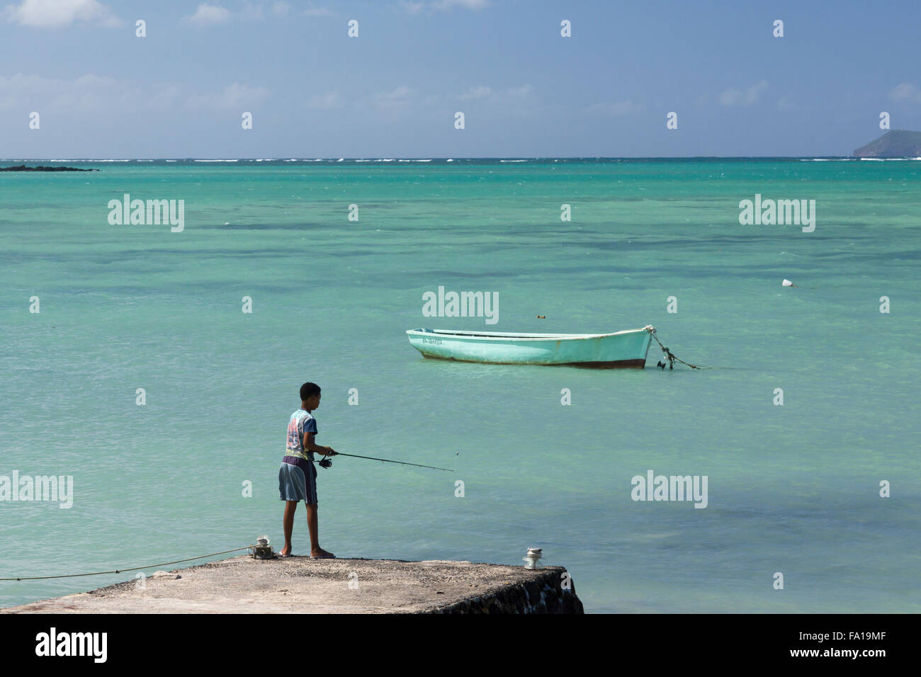 Un locale figlio di Maurizio pesca in Grand Gaube, un piccolo borgo di pescatori in Mauritius Foto Stock