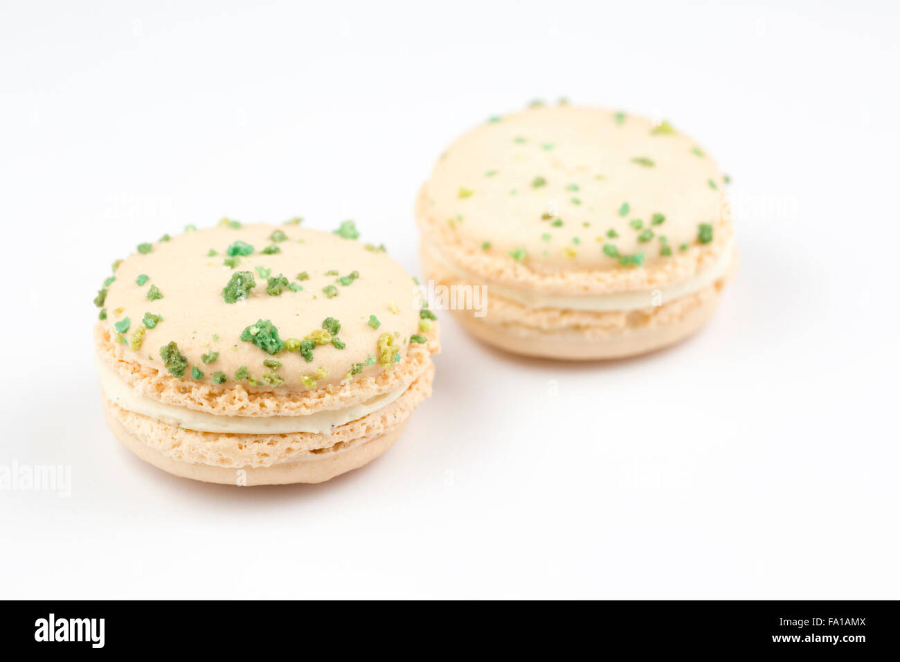 Macaron verdi e bianchi, sapore di vaniglia e basilico, su fondo bianco Foto Stock