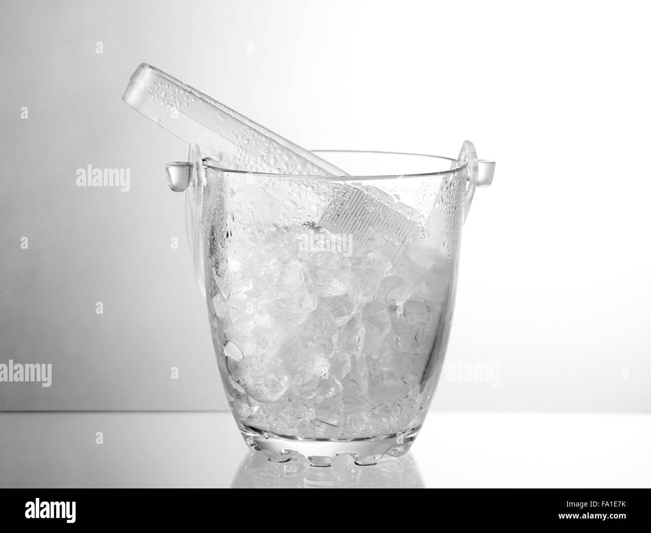 Vetro secchio ghiaccio isolato sul tavolo di vetro Foto Stock
