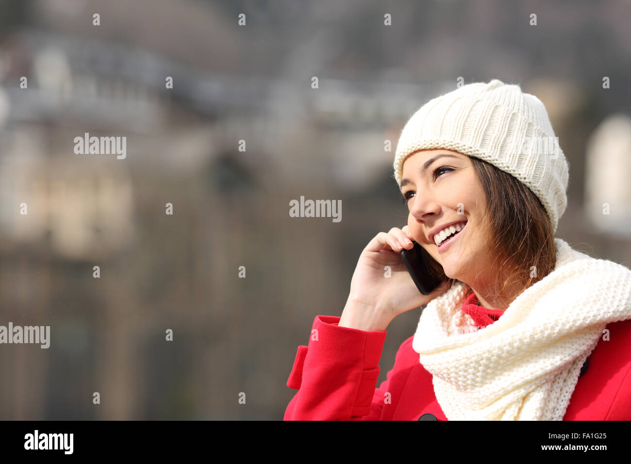 Ragazza parlando al telefono cellulare caldamente vestita in inverno Foto Stock