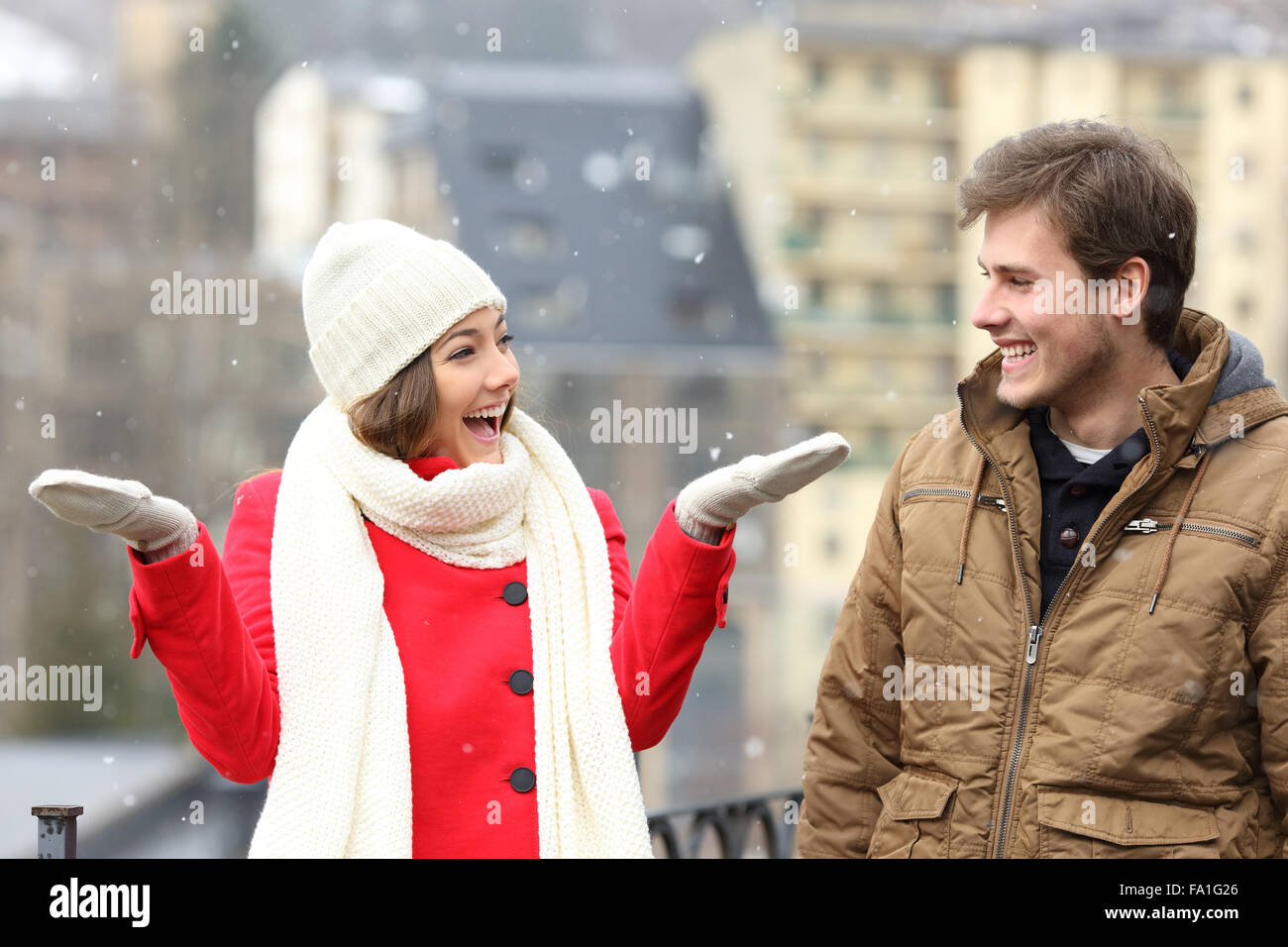 Coppia felice godendo di neve in un giorno di neve nelle strade di una città Foto Stock