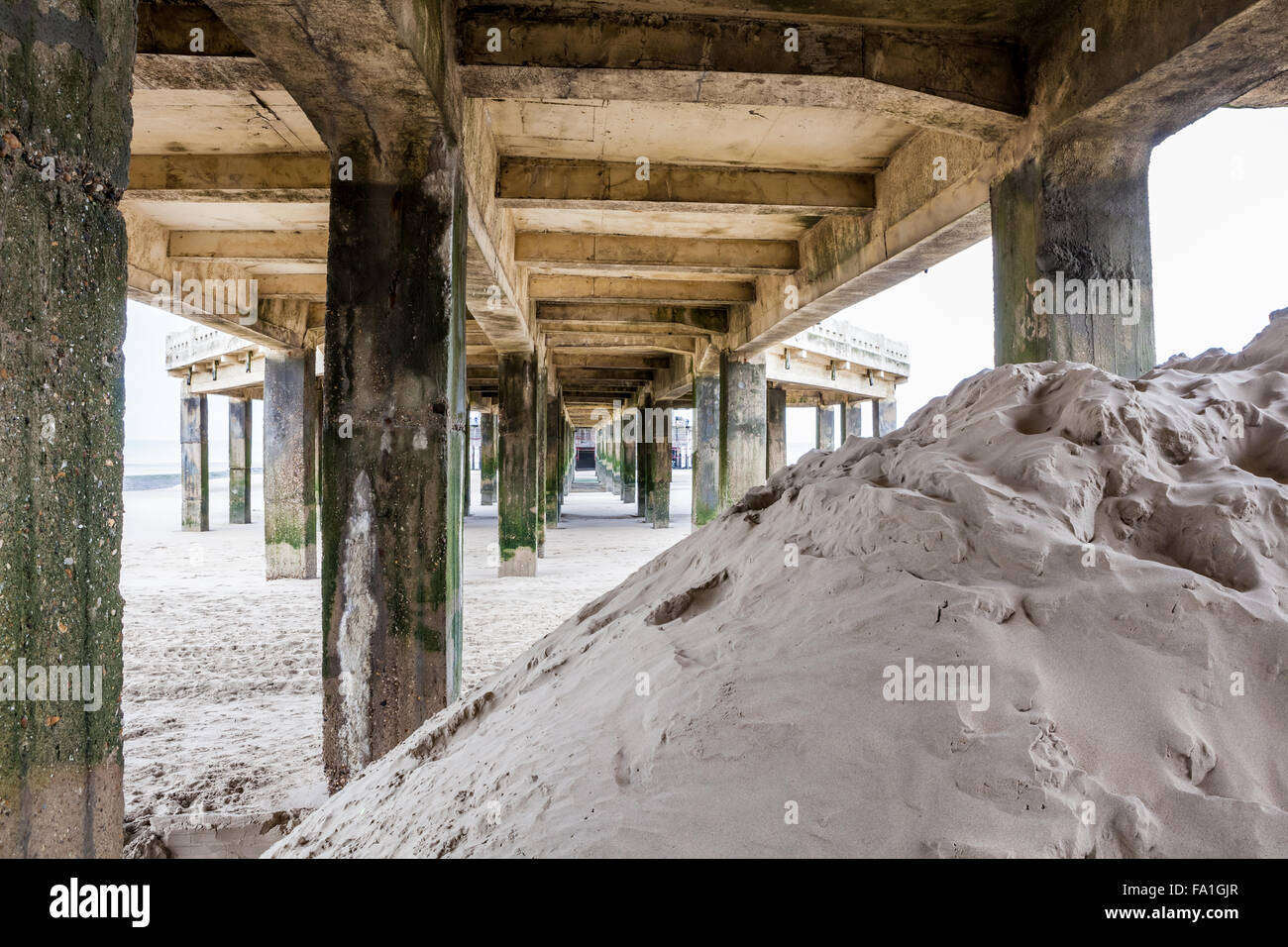 Un sacco di sabbia si trova sotto il molo sul mare Foto Stock