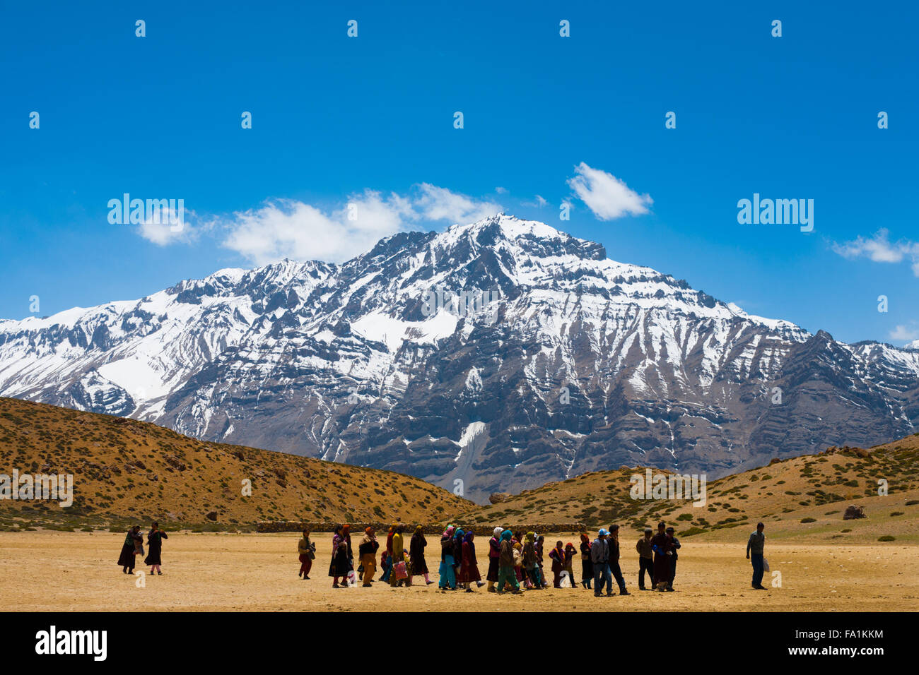 Un gruppo di molti pellegrini buddista camminando sul pellegrinaggio attorno ad un lago santo tra le montagne himalayane in Spiti Valley Foto Stock