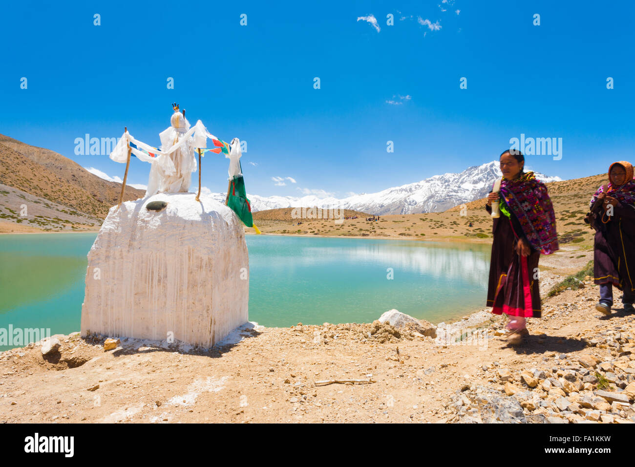 Pellegrini buddista a piedi in pellegrinaggio passato uno stupa intorno a un incontaminato lago alpino in Himalaya nella Spiti Valley Foto Stock