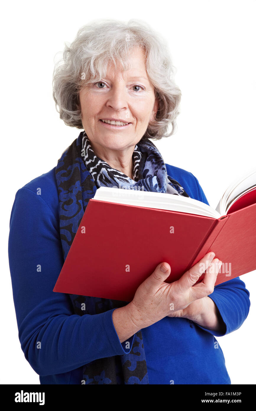 Anziani insegnante femminile la lettura di un libro rosso ad alta voce Foto Stock