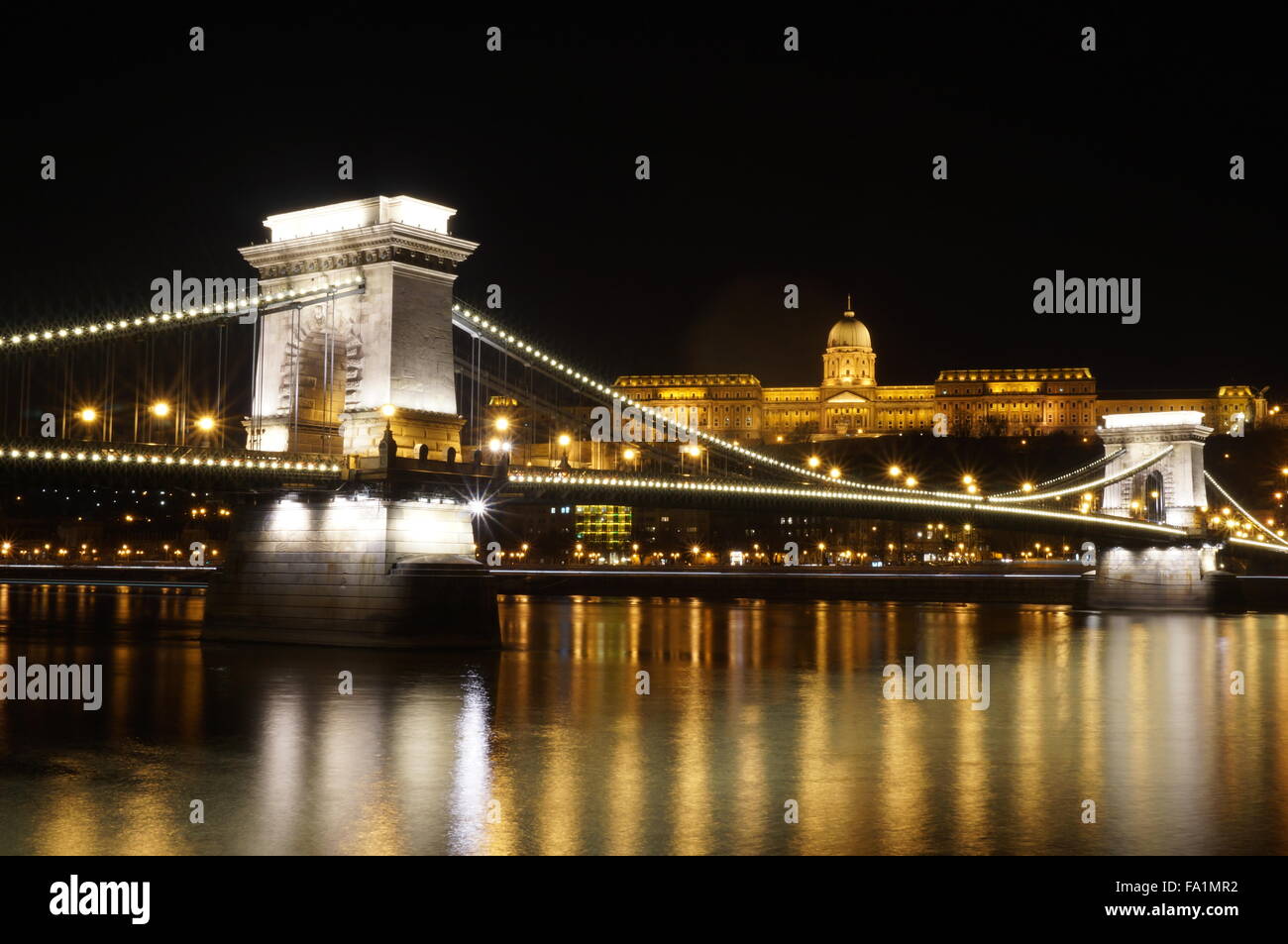 Foto notturna del Ponte delle Catene e il Vecchio Palazzo Reale a Budapest, Ungheria. La riflessione di luce può essere visto al fiume Danubio superficie. Foto Stock