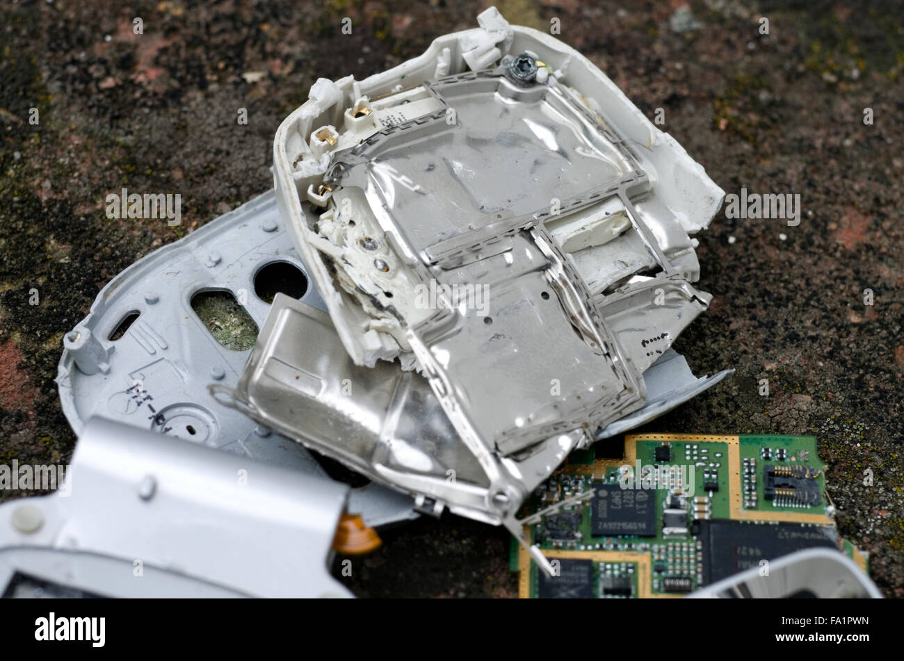 Una pila di pezzi rotti di telefoni cellulari e batterie del telefono Foto Stock