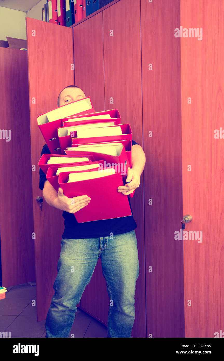 Uomo che porta le cartelle con i documenti - troppi documenti in una sola volta Foto Stock